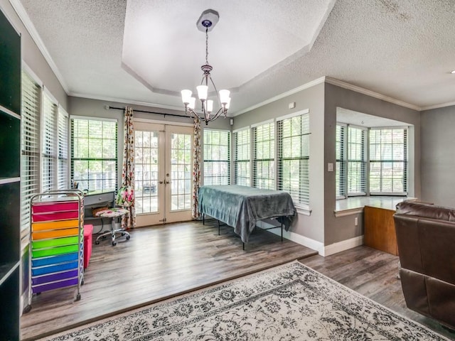 bedroom with a textured ceiling, french doors, wood finished floors, and an inviting chandelier