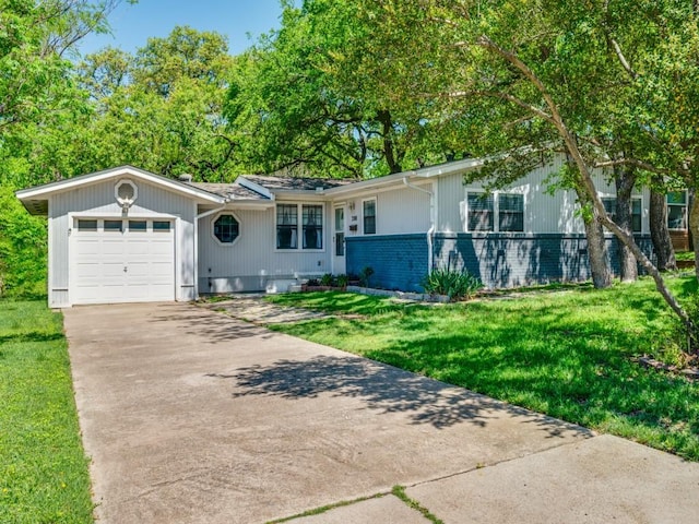 ranch-style home with brick siding, a front lawn, a garage, and driveway