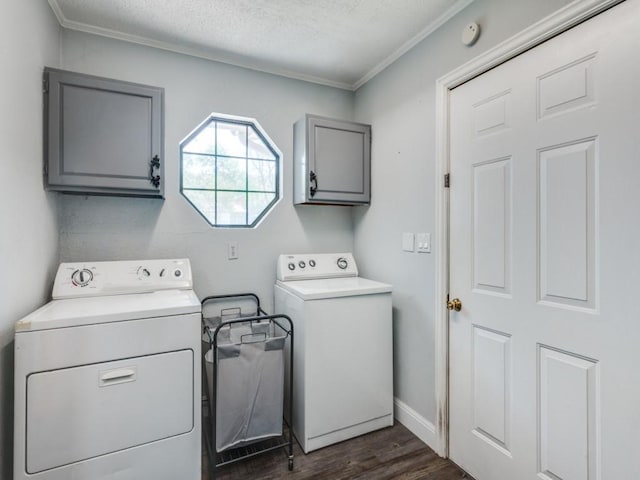 clothes washing area featuring crown molding, dark wood-type flooring, a textured ceiling, separate washer and dryer, and cabinet space