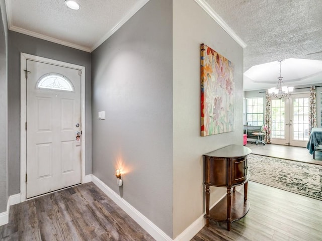 foyer with a textured ceiling, wood finished floors, and a healthy amount of sunlight