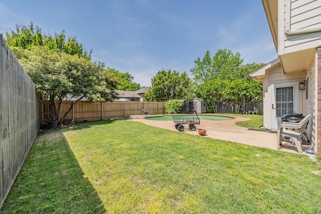 view of yard with a patio, an outbuilding, a fenced backyard, and a shed