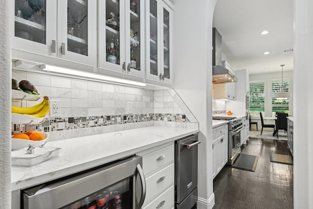 kitchen featuring white cabinets, recessed lighting, visible vents, wall chimney exhaust hood, and double oven range