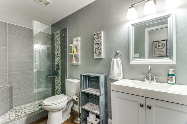 4505 Pangolin Dr, Fort Worth, TX 76244 - full bath featuring wood finished floors, visible vents, toilet, vanity, and a stall shower