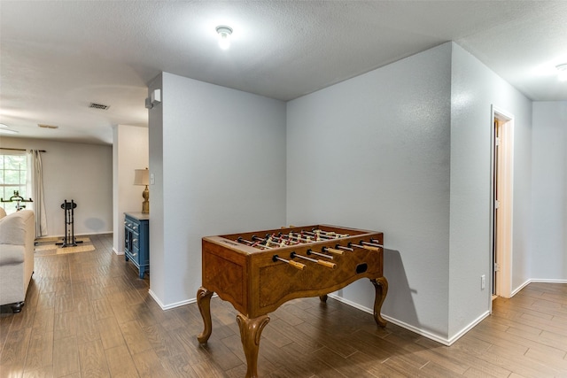 4505 Pangolin Dr, Fort Worth, TX 76244 - rec room featuring baseboards, a wood stove, wood finished floors, and visible vents