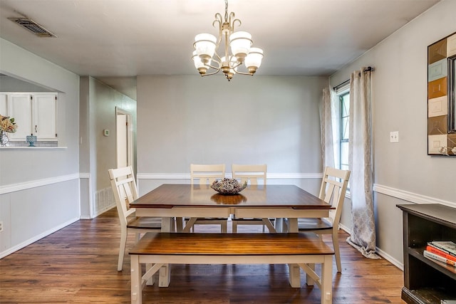 dining area with a chandelier, wood finished floors, baseboards, and visible vents