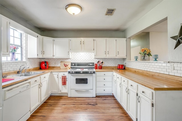 kitchen with white appliances, light countertops, a sink, and decorative backsplash