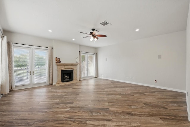 unfurnished living room featuring recessed lighting, visible vents, ceiling fan, a high end fireplace, and wood finished floors