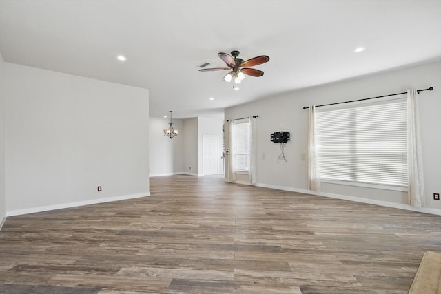 empty room featuring ceiling fan with notable chandelier, wood finished floors, baseboards, and recessed lighting