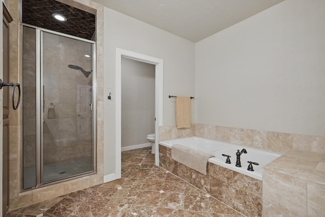 full bathroom with a shower stall, a bath, baseboards, and toilet