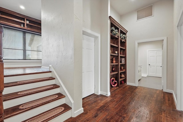 staircase featuring wood finished floors and visible vents