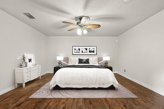 bedroom with visible vents, baseboards, and wood finished floors