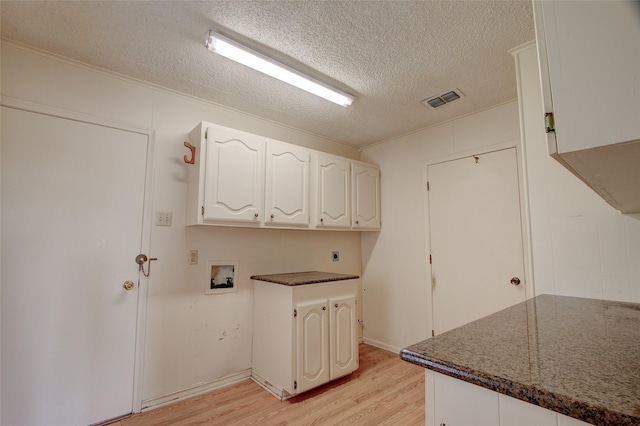 1001 S Sutton St, Mabank, TX 75147 - washroom featuring visible vents, a textured ceiling, cabinet space, light wood finished floors, and hookup for an electric dryer