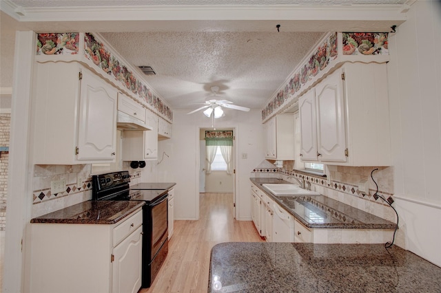 1001 S Sutton St, Mabank, TX 75147 - kitchen featuring decorative backsplash, black range with electric cooktop, light wood-style floors, white cabinets, and a ceiling fan