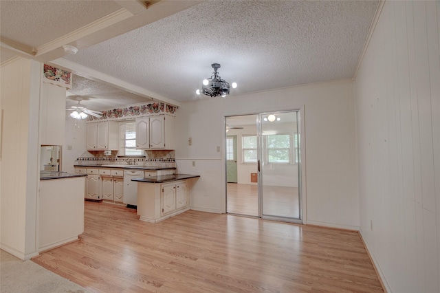1001 S Sutton St, Mabank, TX 75147 - kitchen featuring a peninsula, dark countertops, light wood-type flooring, a textured ceiling, and ceiling fan with notable chandelier