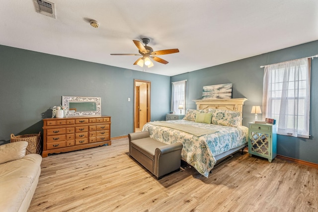 bedroom with wood finished floors, baseboards, a ceiling fan, and visible vents
