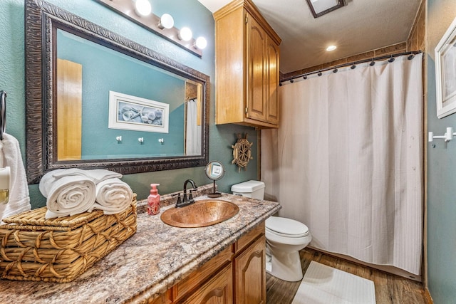 bathroom featuring toilet, a shower with shower curtain, vanity, and wood finished floors