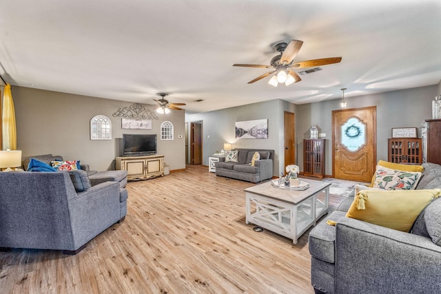 living room featuring light wood finished floors, visible vents, and ceiling fan