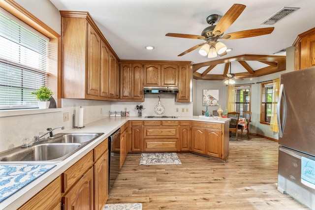 kitchen with freestanding refrigerator, a ceiling fan, under cabinet range hood, visible vents, and a sink