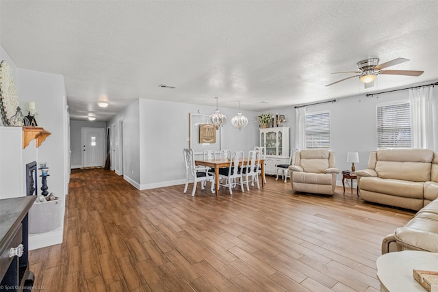 868 Briggs Blvd, East Tawakoni, TX 75472 - living room featuring a textured ceiling, ceiling fan with notable chandelier, wood finished floors, and visible vents