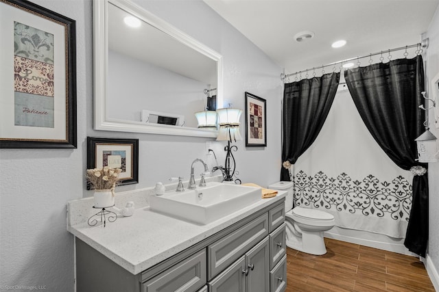 868 Briggs Blvd, East Tawakoni, TX 75472 - full bathroom featuring vanity, recessed lighting, toilet, shower / bathtub combination with curtain, and wood finished floors