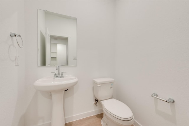 440 Lone Star Dr, Justin, TX 76247 - half bathroom featuring baseboards, toilet, a sink, and wood finished floors