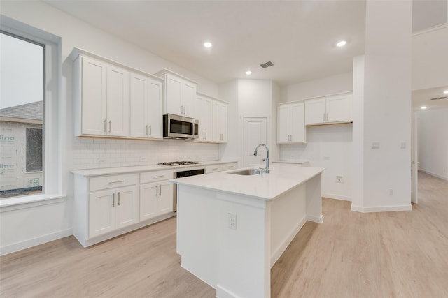 440 Lone Star Dr, Justin, TX 76247 - kitchen with stainless steel microwave, light wood-style flooring, visible vents, and a sink