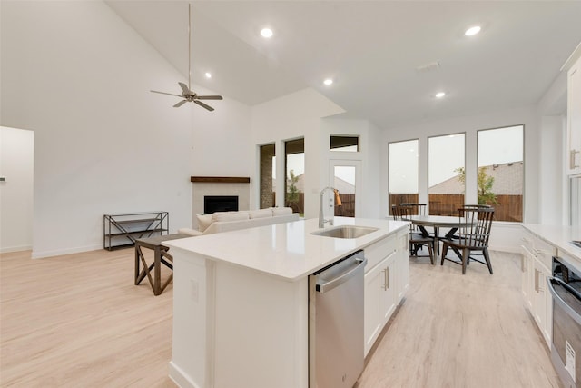 440 Lone Star Dr, Justin, TX 76247 - kitchen featuring a sink, stainless steel appliances, a fireplace, a kitchen island with sink, and light wood-style floors