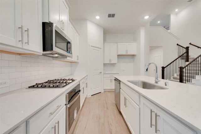 440 Lone Star Dr, Justin, TX 76247 - kitchen with light wood finished floors, visible vents, a sink, white cabinetry, and appliances with stainless steel finishes