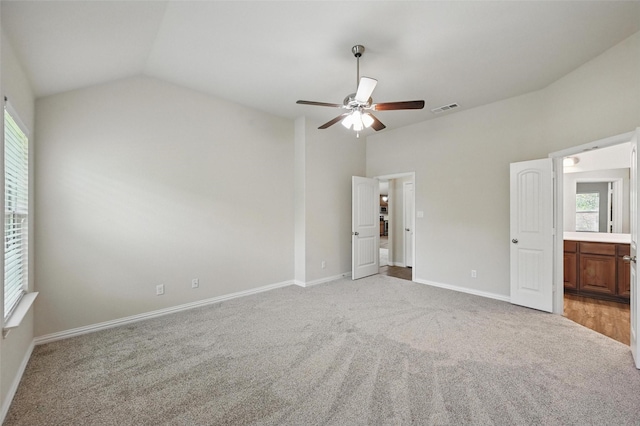 512 Hidden Springs Trl, Azle, TX 76020 - unfurnished bedroom with light colored carpet, lofted ceiling, baseboards, connected bathroom, and ceiling fan