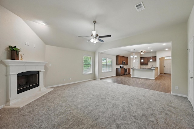 512 Hidden Springs Trl, Azle, TX 76020 - unfurnished living room with light carpet, a ceiling fan, vaulted ceiling, baseboards, and a premium fireplace