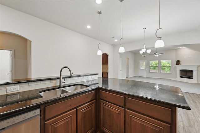 512 Hidden Springs Trl, Azle, TX 76020 - kitchen featuring a sink, arched walkways, dishwasher, a chandelier, and a fireplace