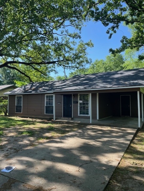 single story home with a shingled roof, concrete driveway, and an attached carport