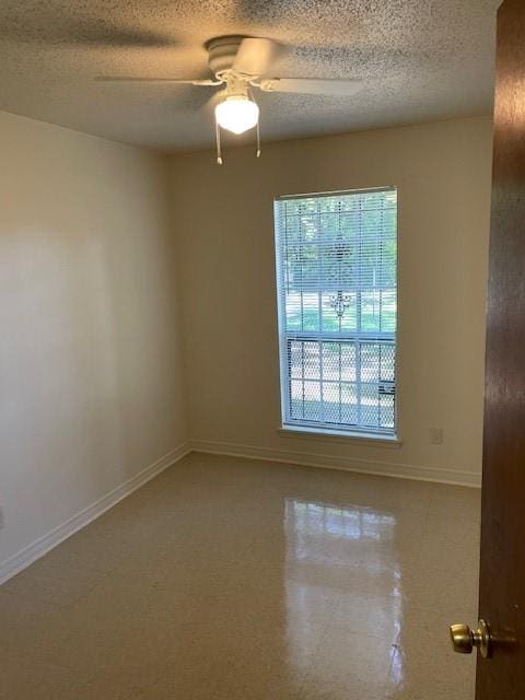 unfurnished room with a textured ceiling, baseboards, and ceiling fan