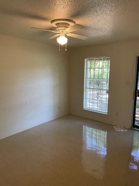 empty room with a textured ceiling, baseboards, and a ceiling fan