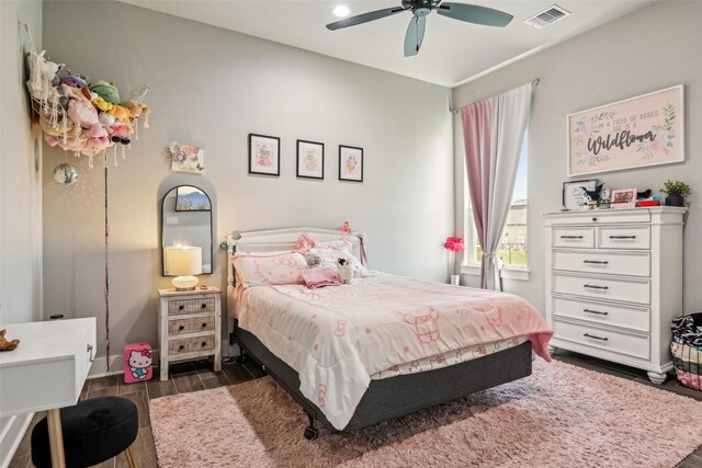 bedroom with dark wood-type flooring, visible vents, baseboards, and ceiling fan