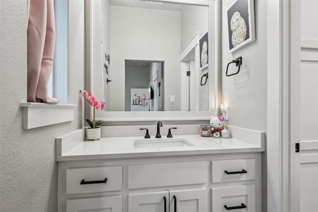 bathroom with vanity and a textured wall