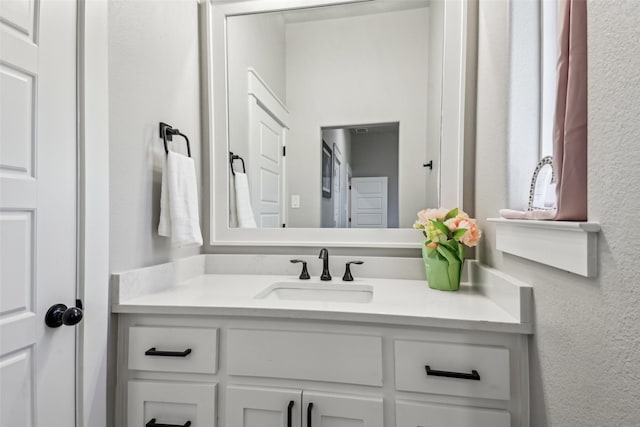 bathroom featuring vanity and a textured wall