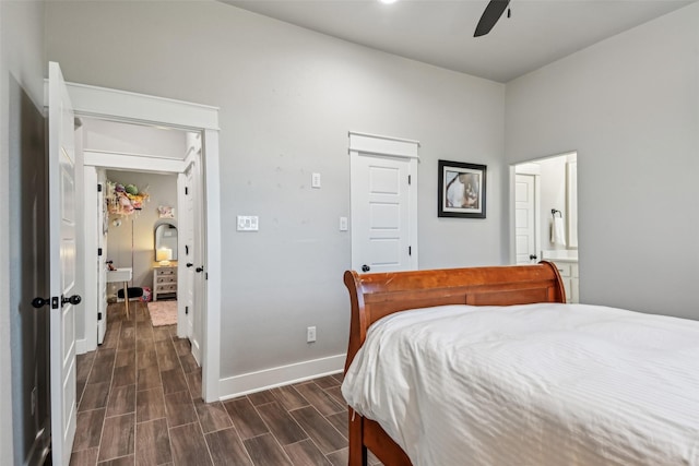 bedroom featuring dark wood-style flooring, baseboards, a ceiling fan, and connected bathroom