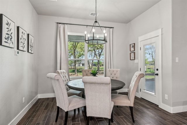 dining space with a notable chandelier, baseboards, and wood tiled floor