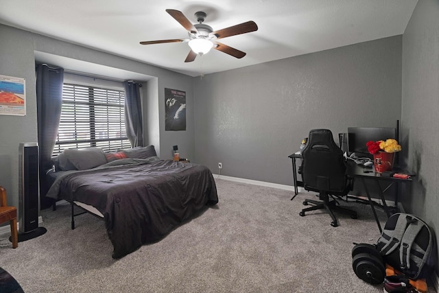 carpeted bedroom with a textured wall, ceiling fan, and baseboards