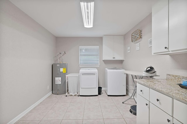 laundry area featuring electric water heater, baseboards, light tile patterned floors, washer and clothes dryer, and cabinet space