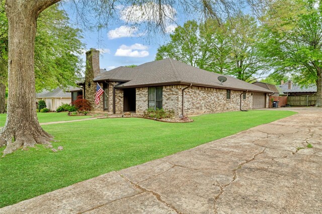 single story home with a front yard, a shingled roof, an attached garage, a chimney, and concrete driveway