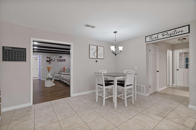 dining area with visible vents, baseboards, a notable chandelier, and light tile patterned floors