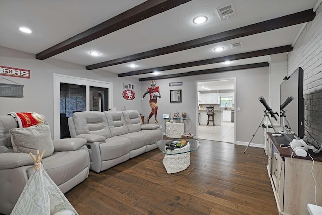 living room with dark wood-type flooring, beamed ceiling, visible vents, and recessed lighting