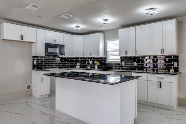 10061 Neosho Dr, Dallas, TX 75217 - kitchen with tasteful backsplash, visible vents, black microwave, and marble finish floor