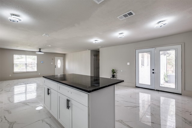 10061 Neosho Dr, Dallas, TX 75217 - kitchen with french doors, dark countertops, white cabinets, visible vents, and marble finish floor