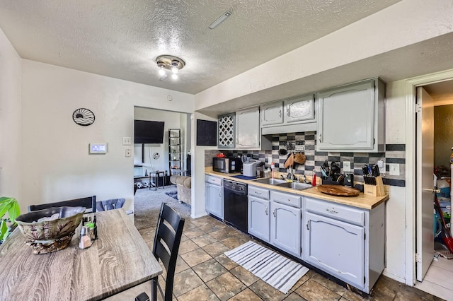kitchen featuring decorative backsplash, black dishwasher, stainless steel microwave, and a sink