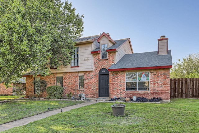 traditional-style house with a chimney, fence, a front lawn, and brick siding