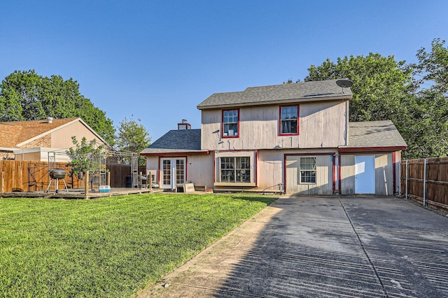 rear view of property with a shingled roof, a deck, a yard, french doors, and fence private yard