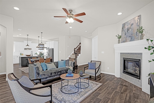 3341 Man O War Rd, Celina, TX 75009 - living area with stairs, dark wood-style floors, ceiling fan, a glass covered fireplace, and recessed lighting